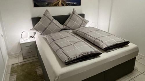 1 cama con 2 almohadas en una habitación en Ferienwohnung Kessler, en Ommersheim