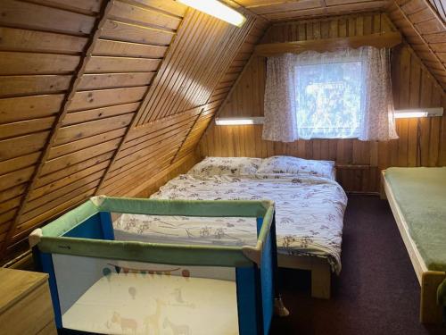 um quarto com uma cama num chalé de madeira em Útulná chaloupka na Valašsku em Valašská Bystřice