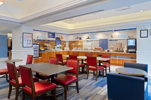 a restaurant with tables and chairs and a kitchen at Holiday Inn Express Hauppauge-Long Island by IHG in Hauppauge
