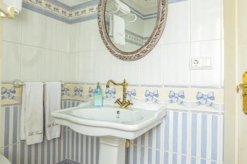 a bathroom with a sink and a mirror at Apartamentos Villa Fresnedo in Solares