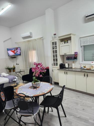 a kitchen and a living room with a table and chairs at Tzimer Lana in Arad