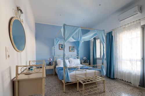 a blue bedroom with a bed with a canopy at Giasemi Room No 5 Astypalea in Livadi Astypalaias