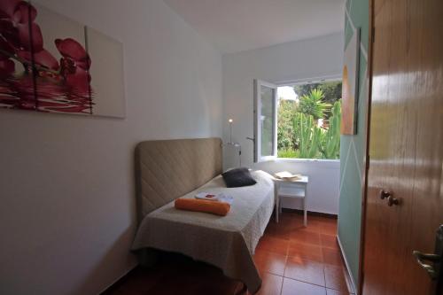 カラ・ガルダナにあるCasa Dieterのベッドと窓が備わる小さな客室です。