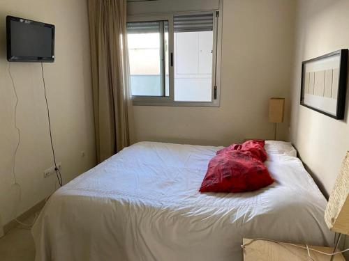 a bedroom with a bed with a red pillow on it at Belmar in Les Cases d'Alcanar