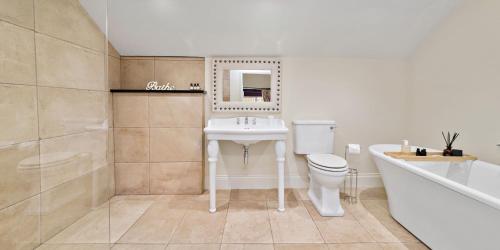 a bathroom with a sink and a toilet and a tub at Chantry House in Barnsley