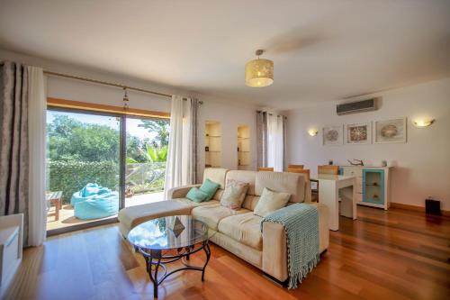 een woonkamer met een bank en een tafel bij Luxury Apartment with Pool in Albufeira