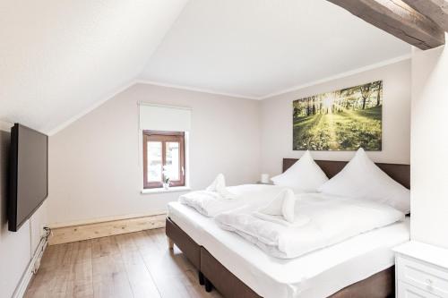 sypialnia z dużym łóżkiem z białą pościelą w obiekcie Ferienwohnung Ziesing Gernrode w mieście Gernrode - Harz