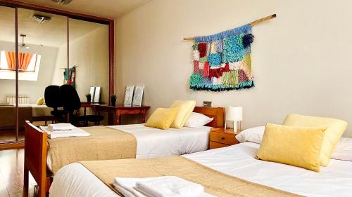 Zimmer mit 3 Betten und einer Decke an der Wand in der Unterkunft Housingleón - Conde Duplex con garaje gratuito in León