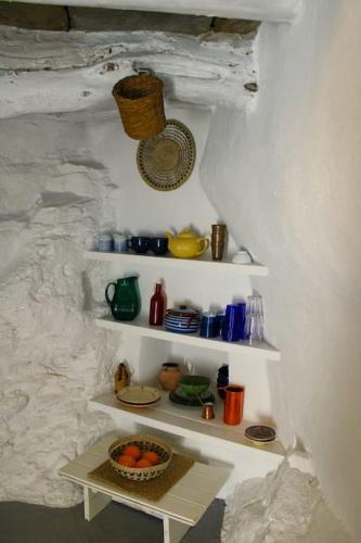 a white shelf with a bowl of oranges on it at Thimari cottage in Andros in ayios Petros