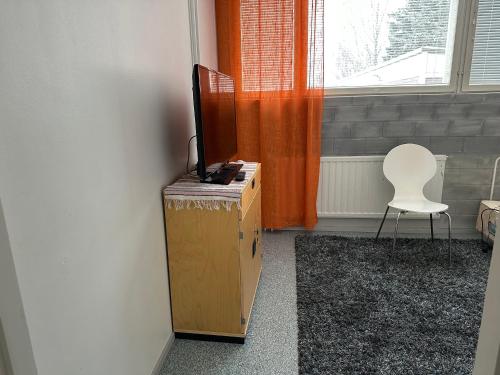 Zimmer mit einem TV auf einer Schachtel und einem Stuhl in der Unterkunft Huoneisto kaupungissa Ylivieska in Ylivieska