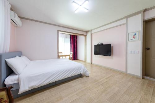 a bedroom with a bed and a flat screen tv at Clear morning pet friendly pension in Gyeongju