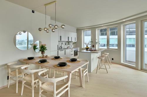 a kitchen and dining room with a table and chairs at Brand new and luxurious penthouse in Bergen city centre! in Bergen