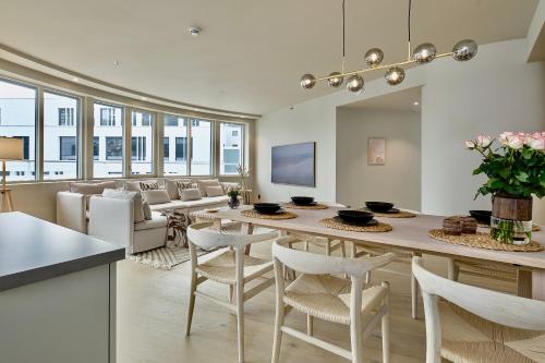 a kitchen and living room with a table and chairs at Brand new and luxurious penthouse in Bergen city centre! in Bergen