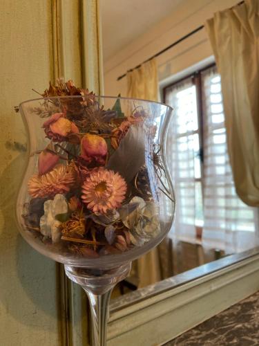 a glass vase filled with flowers in front of a mirror at Maison 1823 - Suites de charme à Garons in Garons