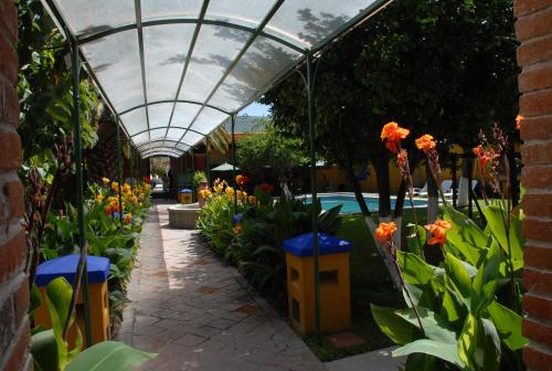 a greenhouse with orange flowers in a garden at Hotel Hacienda Don Cenobio in San Pablo Villa de Mitla