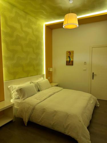 a bedroom with a large bed with a yellow wall at AL BON Park in Berat