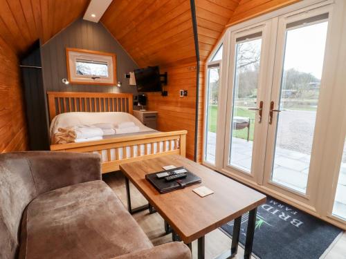 a room with a bed and a desk and a table at Acorn Lodge At Bridge Lake Farm & Fishery in Banbury