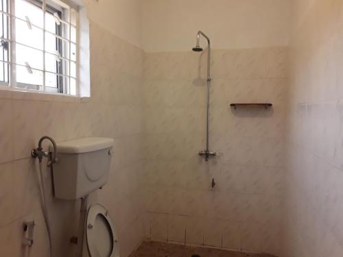 a bathroom with a toilet and a shower in it at Pazuri House Iringa in Iringa