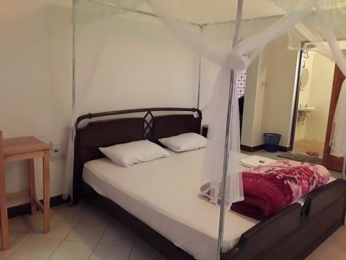 a bed with a canopy in a room at Pazuri House Iringa in Iringa