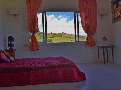 a bedroom with a bed and a large window at Bel ombre's Panoramic view in Bel Ombre