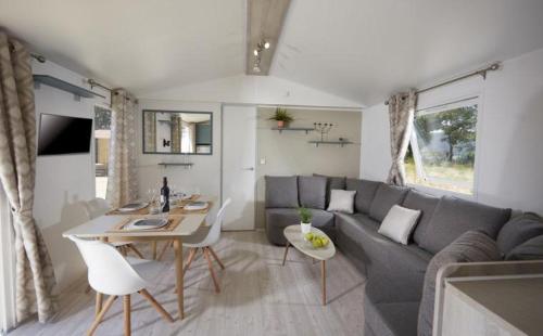 a living room with a couch and a table at Grand mobil home tout confort ES 93 in Fréjus