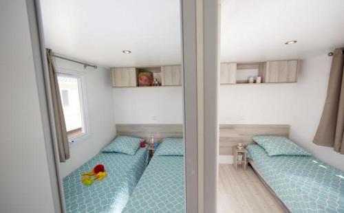 a room with two beds in a room at Grand mobil home tout confort ES 93 in Fréjus