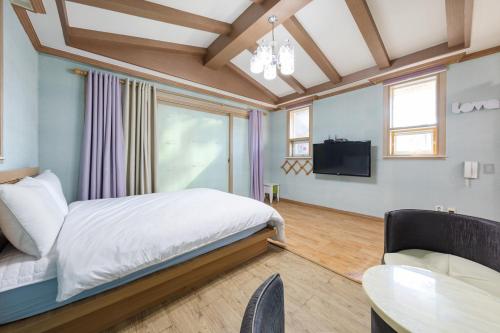 um quarto com uma cama, uma televisão e uma mesa em Clear morning pet friendly pension em Gyeongju