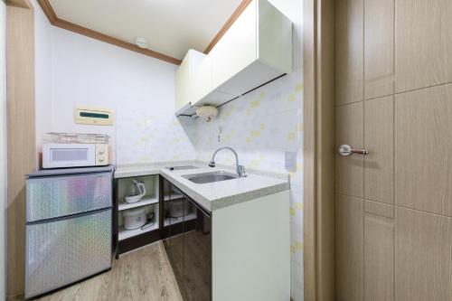 a small kitchen with a sink and a microwave at Clear morning pet friendly pension in Gyeongju
