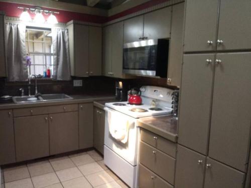 a kitchen with a white stove top oven next to a sink at Home of the Brave 2 in Lawton