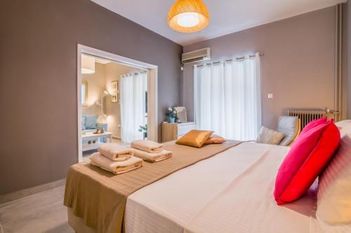 um quarto com uma cama grande com almofadas vermelhas em Glyfada's Central Apartment em Atenas