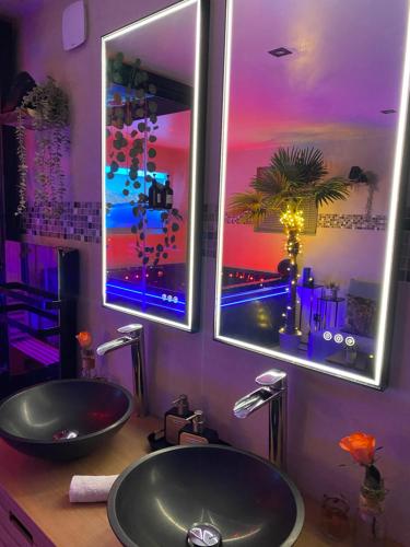 a bathroom with two sinks and two mirrors at BIOTY CHILL & SPA in Le Blanc-Mesnil