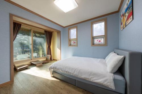 um quarto com uma cama e duas janelas em Clear morning pet friendly pension em Gyeongju
