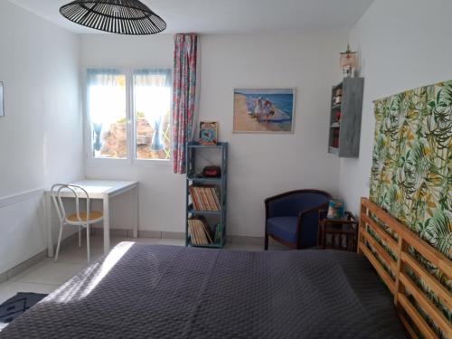 Schlafzimmer mit einem Bett, einem Schreibtisch und einem Stuhl in der Unterkunft la belle bleue in Banyuls-sur-Mer