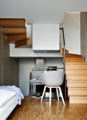 a bedroom with a white chair next to a bed at Hotel Wedina an der Alster in Hamburg