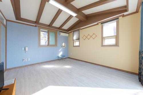 an empty room with blue walls and windows at Clear morning pet friendly pension in Gyeongju