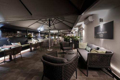 un restaurante con sofás, mesas y sillas en Hotel 77 Seventy-Seven - Maison D'Art Collection, en Roma