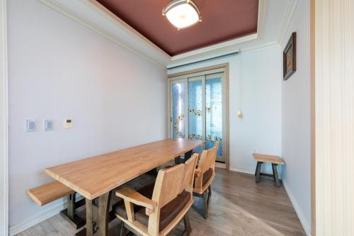 a dining room with a wooden table and chairs at Clear morning pet friendly pension in Gyeongju