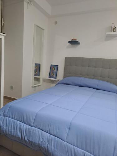 a bedroom with a blue bed with two pictures on the wall at supportico home in Naples