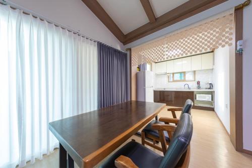 a kitchen with a wooden table and two chairs at Clear morning pet friendly pension in Gyeongju