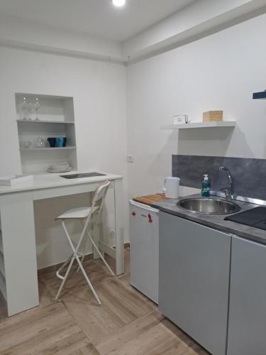 a white kitchen with a sink and a counter at supportico home in Naples