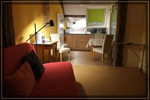 ein Wohnzimmer mit einem Sofa und einem Tisch sowie eine Küche in der Unterkunft Studio in der alten Scheune in Eschbach