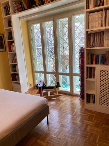 a bedroom with a bed and a large window at MAGGIE HOUSE in Rome