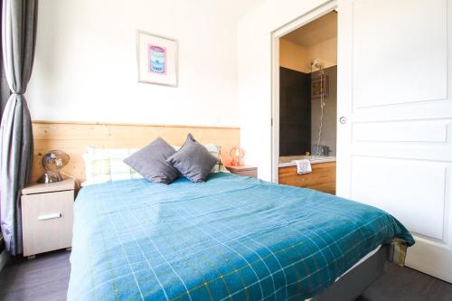 une chambre avec un lit avec une couette bleue dans l'établissement Penthouse 3-bedroom apartment, mountain views, large terrasse, piste access, à Flaine