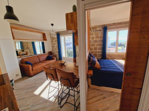 une chambre avec une table et un lit ainsi qu'un salon dans l'établissement Incroyable T2 plein de charme avec balcon vue mer à l'entrée d'Ajaccio, à Ajaccio