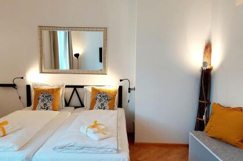 a bedroom with two beds with a mirror on the wall at Homelystay Graz - downtown app in Graz
