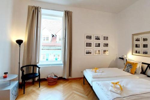 1 dormitorio con 2 camas y ventana grande en Homelystay Graz - downtown app en Graz