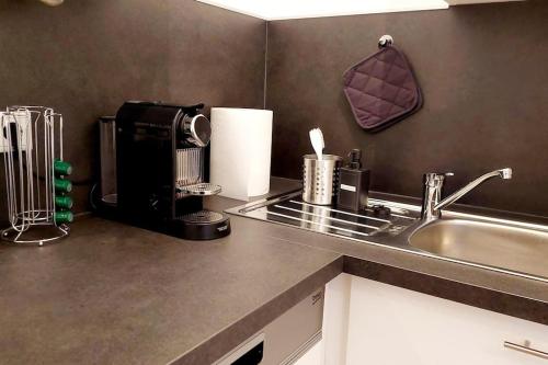 a kitchen counter with a coffee maker and a sink at Homelystay Graz - downtown app in Graz