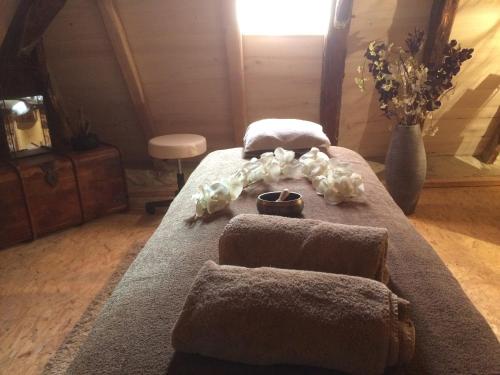 een slaapkamer met een bed met 2 kussens en handdoeken bij Domaine de Galoubet, Lot , Gîtes de charme in Beaumat