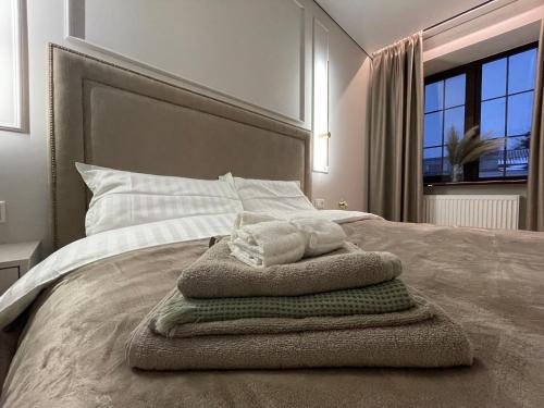 1 dormitorio con 1 cama con toallas en Downtown Apartment en Chernihiv