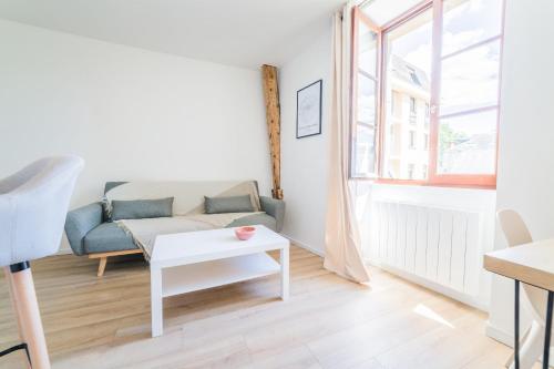 un salon avec un canapé et une table dans l'établissement Logis Cosy sur la Guierle - 1 Chambre, à Brive-la-Gaillarde